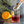 Load image into Gallery viewer, Glass with red liquid, orange, and tongs on a kitchen counter. Clear ice sphere maker, ice ball press kit by pressice barware.